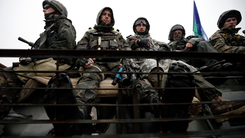 Ukrainian servicemen sit on their armoured vehicle near the village of Luhanske
