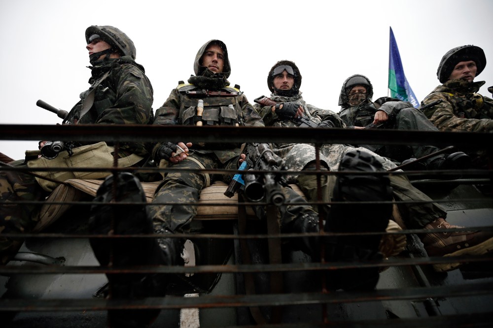 Ukrainian servicemen sit on their armoured vehicle near the village of Luhanske