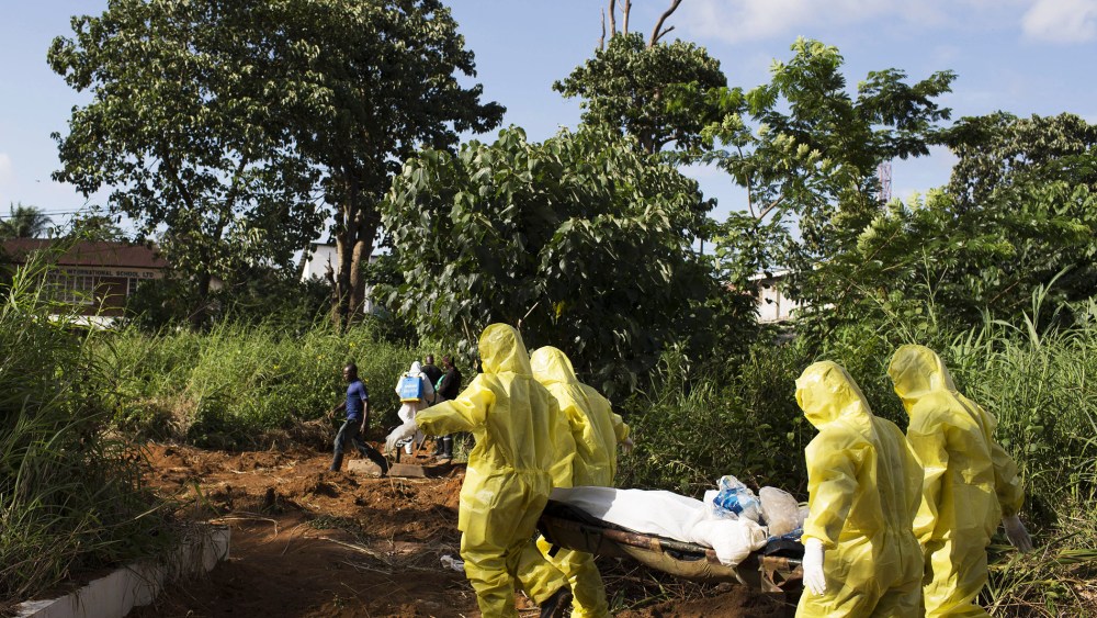 A burial team wearing protective clothing prepared the body of a person suspected to have died of the Ebola virus for interment, in Freetown, Sierra Leone, on Sept. 28, 2014.