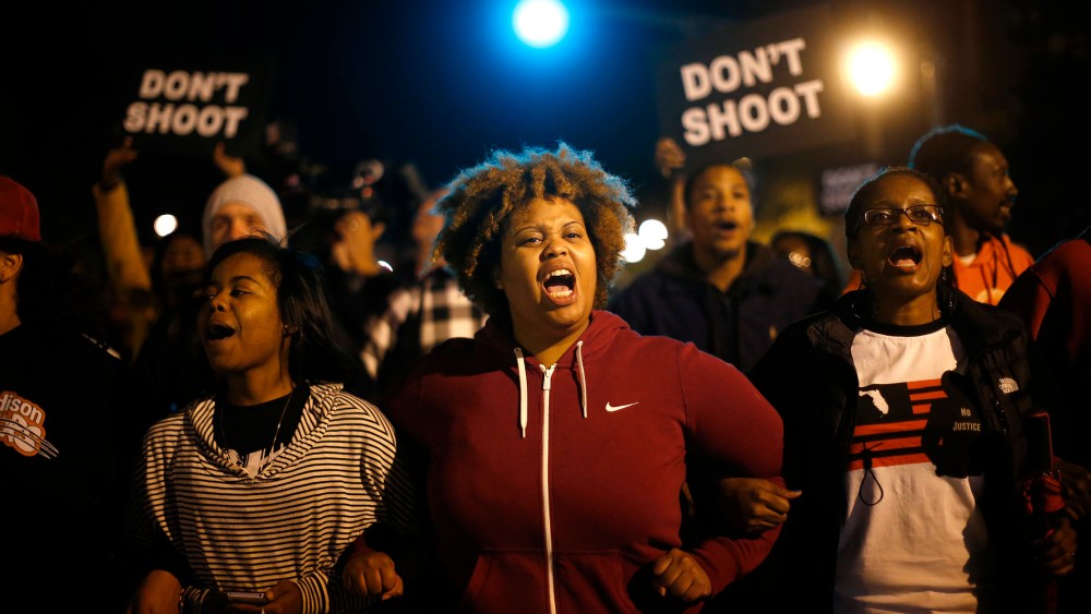 Protesters link arms after blocking an intersection after a vigil in St. Louis, Missouri, on Oct. 9, 2014.