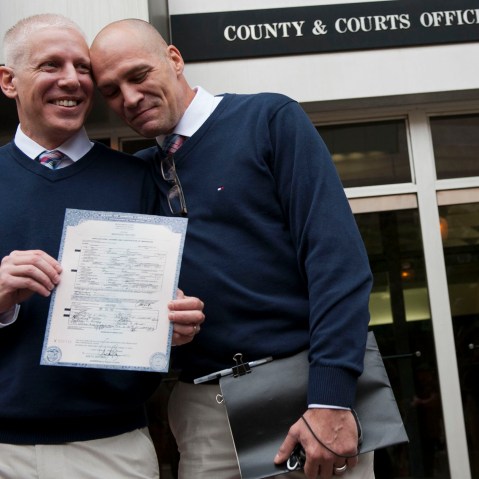 Terrence Hall (L) and Christopher DeCaria (R) display their marriage license to the media outside of the Mecklenburg County Register of Deeds office in Charlotte, North Carolina, on Oct. 13, 2014.