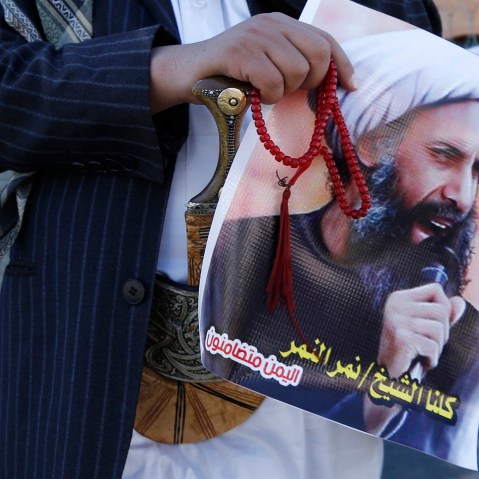 A Shi'ite protester carries a poster of Sheikh Nimr al-Nimr during a demonstration outside the Saudi embassy in Sanaa, Oct. 18, 2014. (Photo by Khaled Abdullah/Reuters)