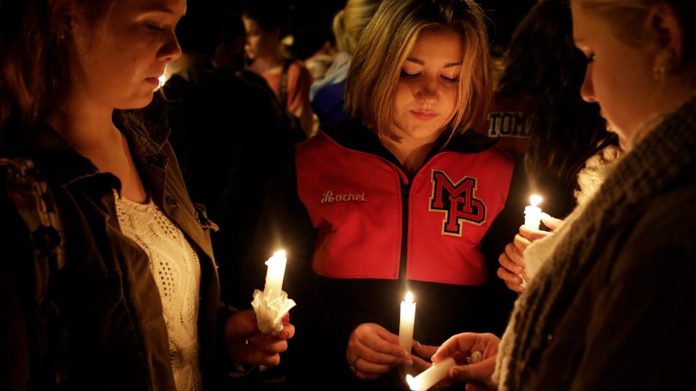 Katelynn Janisko (L-R), 15, Rachel Cowan, 15, and Jamison Strickland, 15, light candles at a vigil after a shooting at Marysville-Pilchuck High School in Marysville, Wash., Oct. 24, 2014. (Photo by Jason Redmond/Reuters)