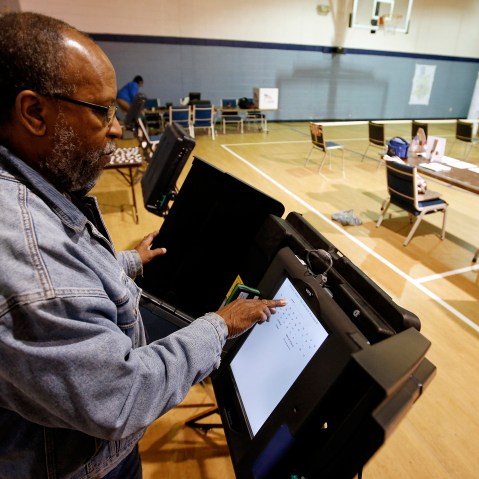 Poll worker Willie Stafford Jr. programs a voting terminal before the start of the voting at the Grove Presbyterian Church in Charlotte, NC, Nov. 4, 2014. (Photo by Chris Keane/Reuters)