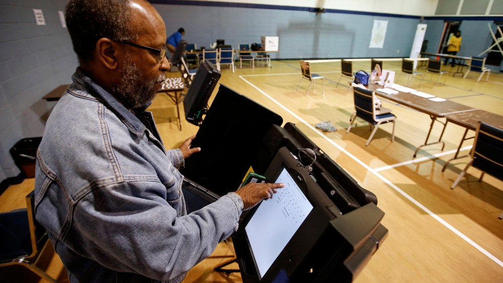 Poll worker Willie Stafford Jr. programs a voting terminal before the start of the voting at the Grove Presbyterian Church in Charlotte, NC, Nov. 4, 2014. (Photo by Chris Keane/Reuters)