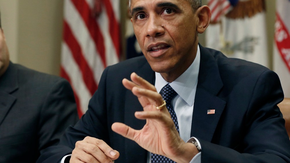 U.S. President Barack Obama sits next to Ebola response coordinator Ron Klain (L) as he hosts a meeting with his Ebola response team in the Roosevelt Room of the White House in Washington