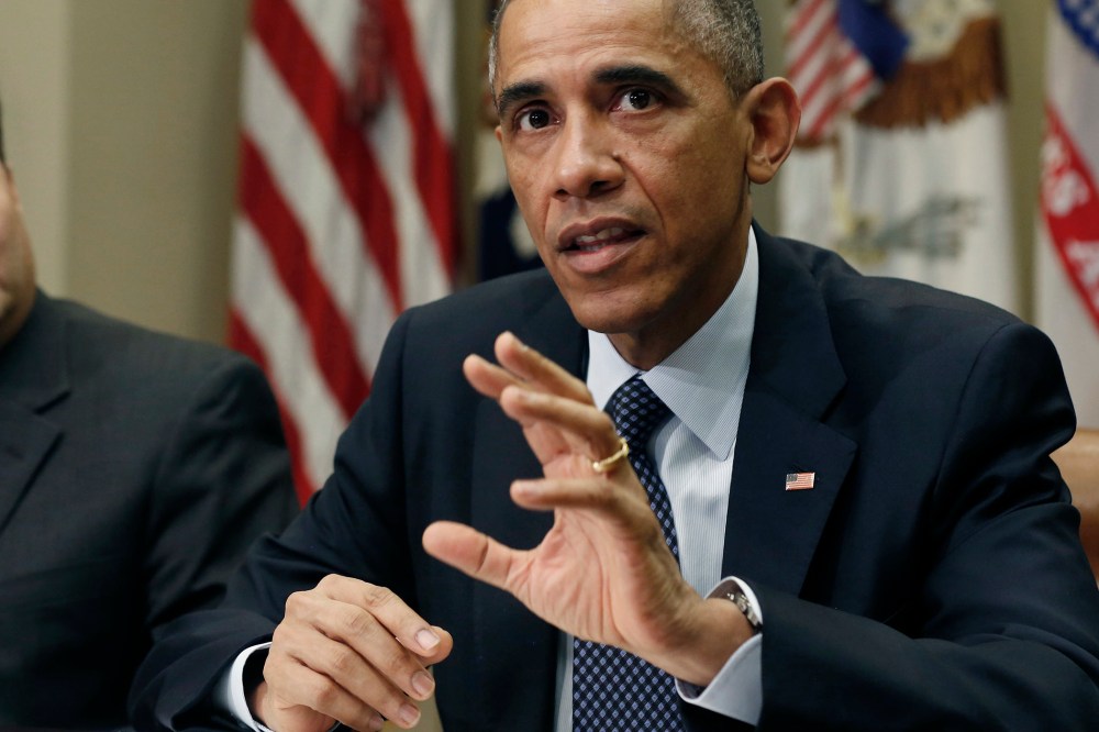 U.S. President Barack Obama sits next to Ebola response coordinator Ron Klain (L) as he hosts a meeting with his Ebola response team in the Roosevelt Room of the White House in Washington