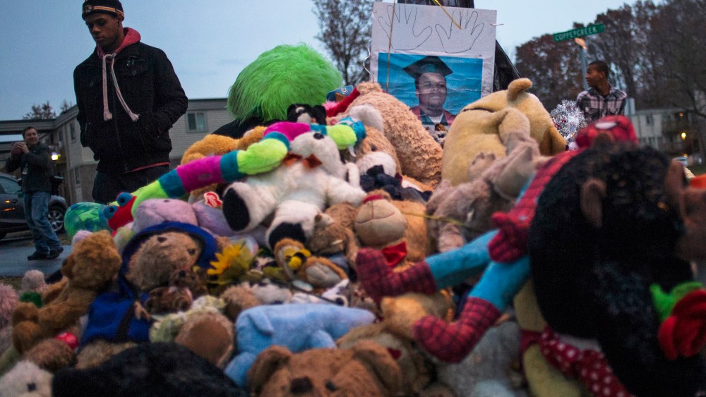 A resident walks past an image of 18-year-old Michael Brown placed at a makeshift memorial near the site where he was shot and killed in Ferguson, Mo. on Nov. 22, 2014. (Adrees Latif/Reuters)