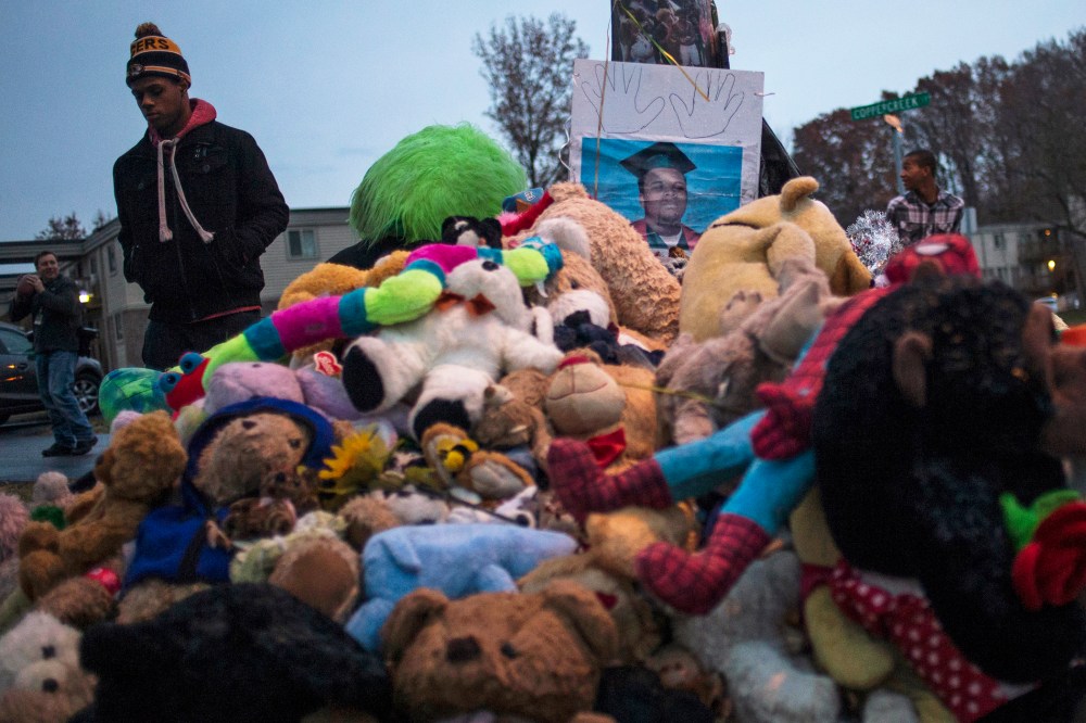 A resident walks past an image of 18-year-old Michael Brown placed at a makeshift memorial near the site where he was shot and killed in Ferguson, Mo. on Nov. 22, 2014. (Adrees Latif/Reuters)