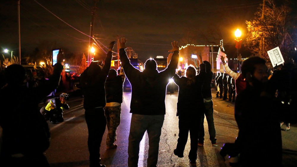Protesters approach a police line with their hands up after a grand jury returned no indictment in the shooting of Michael Brown in Ferguson, Mo. on Nov. 24, 2014. (Photo by Adrees Latif/Reuters)
