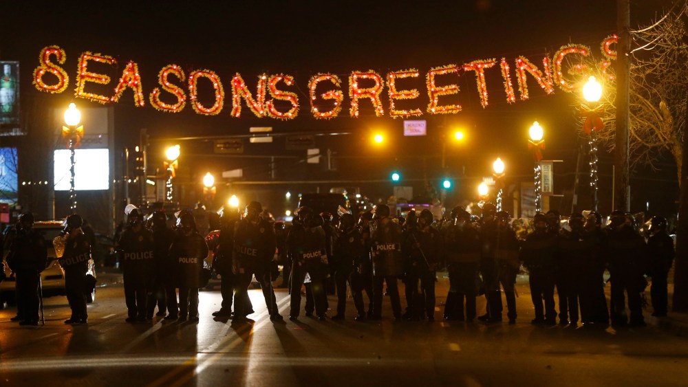 Police form a line in the street under a holiday sign after a grand jury returned no indictment in the shooting of Michael Brown in Ferguson, Missouri