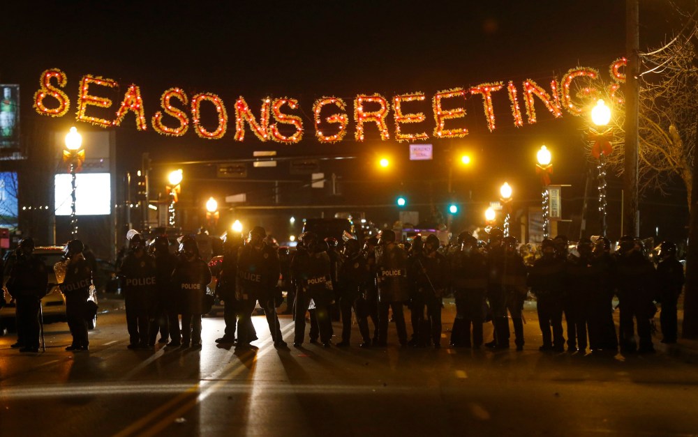 Police form a line in the street under a holiday sign after a grand jury returned no indictment in the shooting of Michael Brown in Ferguson, Missouri