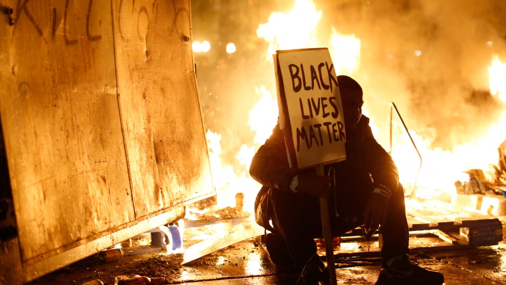 A demonstrator sits in front of a street fire during a demonstration following the grand jury decision in the Ferguson, Mo. shooting of Michael Brown, in Oakland, Calif. Nov. 25, 2014. (Photo by Stephen Lam/Reuters)