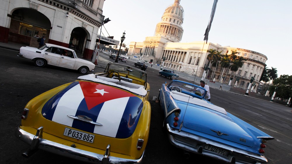 A car with a Cuban flag is parked near Cuban Capitol in Havana on Dec. 18, 2014. (Photo by Enrique de la Osa/Reuters)