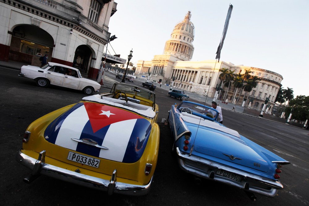 A car with a Cuban flag is parked near Cuban Capitol in Havana on Dec. 18, 2014. (Photo by Enrique de la Osa/Reuters)