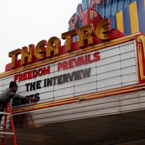 General Manager Delaney puts letters on the marquee sign after the announcement that the Plaza Theatre would be showing the movie "The Interview" in Atlanta