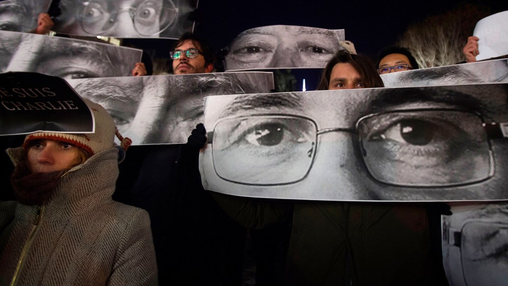 People hold up posters with the eyes of Charlie Hebdo Editor Stephane Charbonnier (front) and Jean Cabut (back L) during a vigil to pay tribute to the victims of the Paris shooting, in the New York City Jan. 7, 2015. (Photo by Carlo Allegri/Reuters)