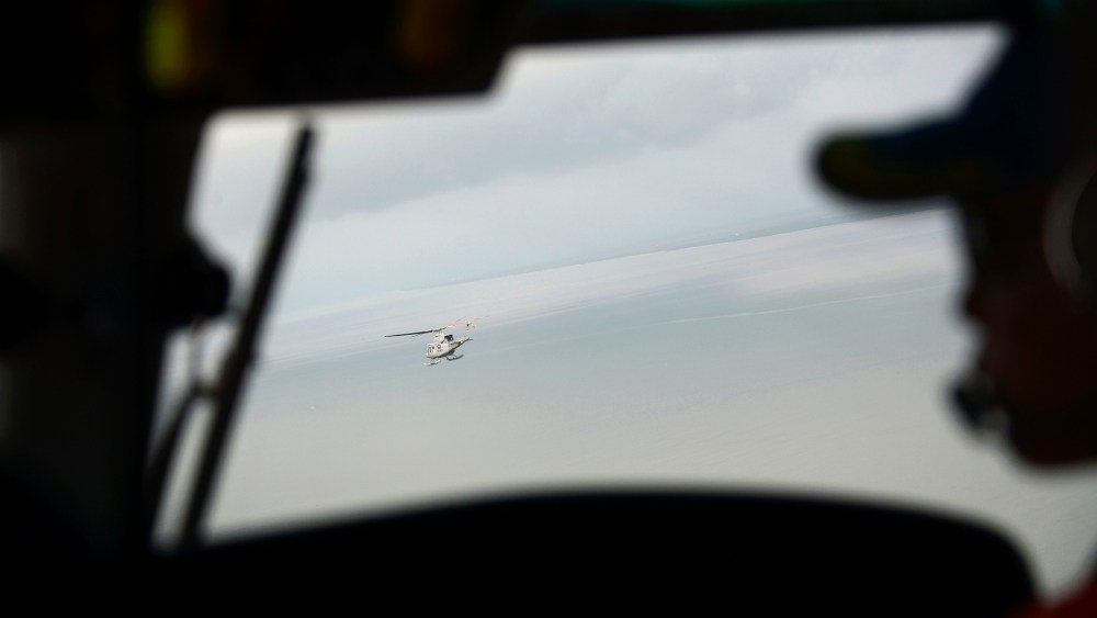 Indonesian navy helicopters head to the navy vessel KRI Banda Aceh, close to an area where the team found the tail of AirAsia QZ8501 in the Java sea on Jan. 8, 2015. (Photo by Adek Berry/Pool/Reuters)