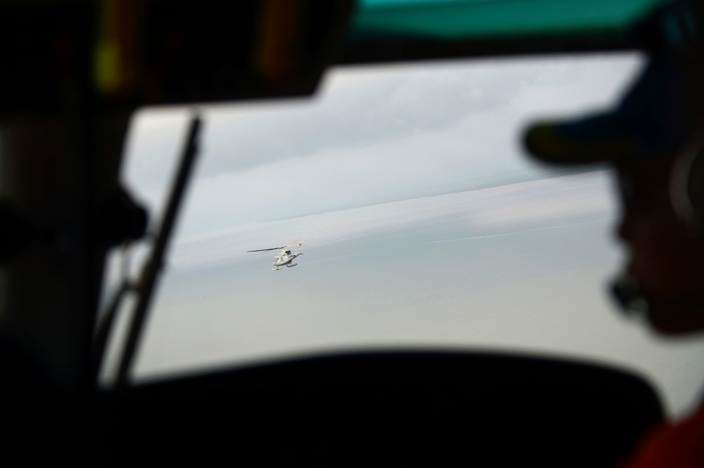 Indonesian navy helicopters head to the navy vessel KRI Banda Aceh, close to an area where the team found the tail of AirAsia QZ8501 in the Java sea on Jan. 8, 2015. (Photo by Adek Berry/Pool/Reuters)