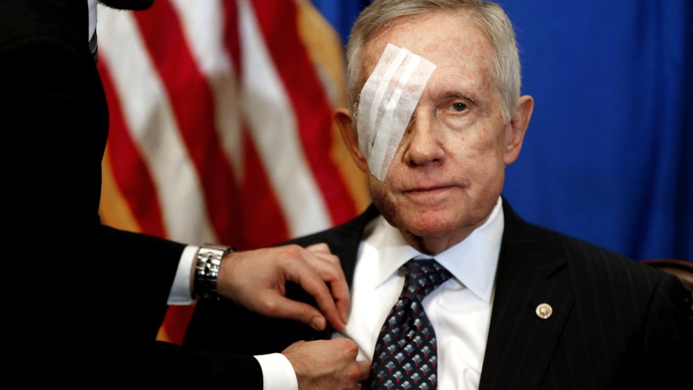 An aide attaches a microphone as U.S. Senate Minority Leader Harry Reid sits down for a news conference in his office at the U.S. Capitol in Washington Jan. 22, 2015. (Photo by Jonathan Ernst/Reuters)
