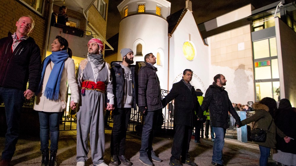 More than 1000 Muslims join hands to form a human shield, dubbed a ring of peace, around a synagogue in Oslo Feb. 21, 2015, offering symbolic protection for the city's Jewish community. (Photo by Hakon Mosvold Larsen/Reuters)