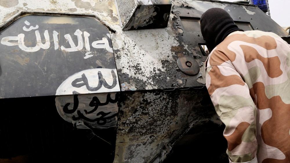 A Chadian soldier peers into a burnt armored vehicle, which the Chadian military say belonged to insurgent group Boko Haram, after the Chadians destroyed it during battle in Gambaru, Feb. 26, 2015. (Photo by Emmanuel Braun/Reuters)