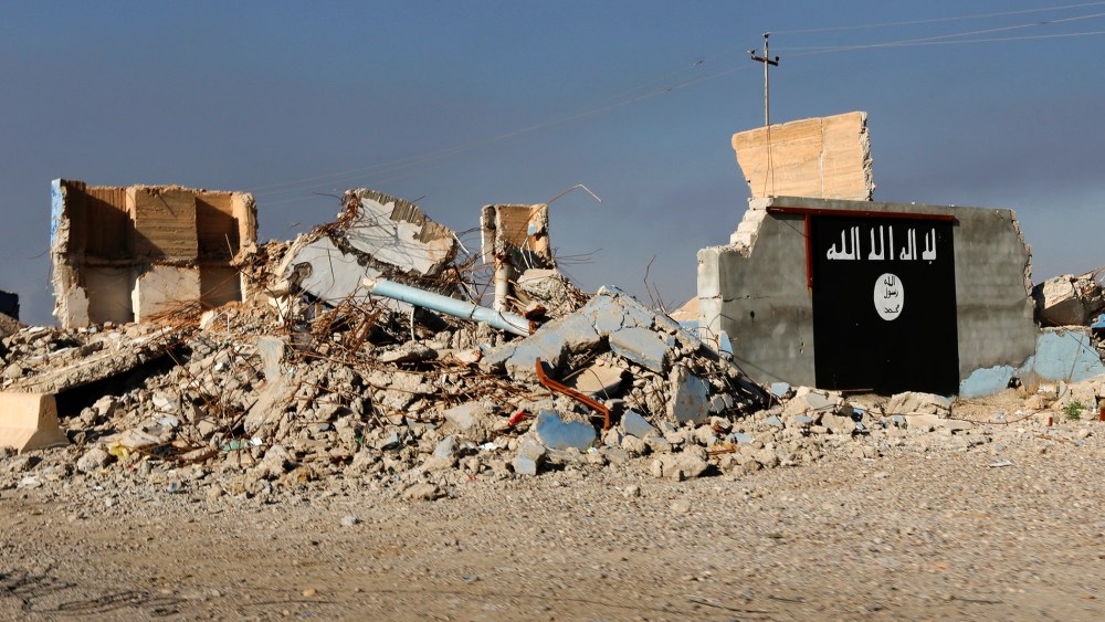 A destroyed building with a wall painted with the black flag commonly used by Islamic State militants is seen, March 10, 2015. (Photo by Thaier Al-Sudani/Reuters)