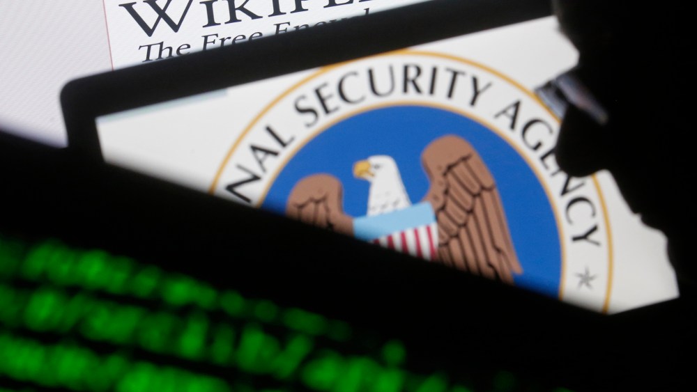 A man is seen near cyber code and the U.S. National Security Agency logo in this photo illustration taken in Sarajevo March 11, 2015. (Photo by Dado Ruvic/Reuters)