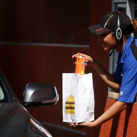 A McDonald's employee passes an order to a driver at a drive through restaurant in Los Angeles, Calif. on March 17, 2015.