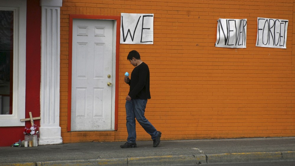 A boy with an ice-cream cone walks past a memorial to Antonio Zambrano-Montes in Pasco, Washington, March 21, 2015. (Photo by Action Images/Reuters)