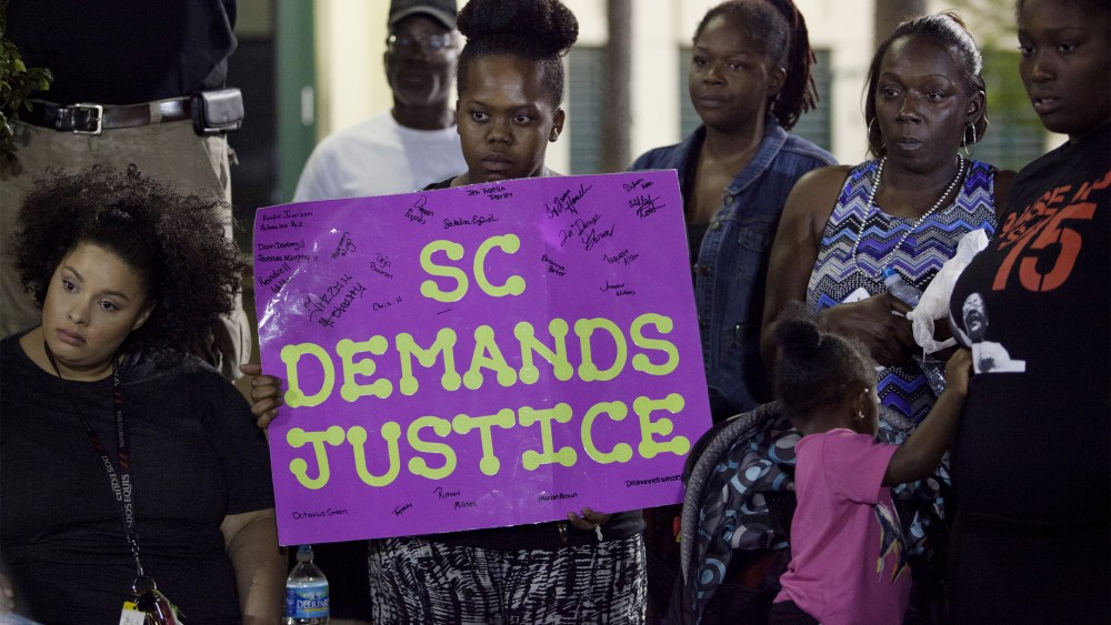 A protester holds a sign during a late rally at city hall in North Charleston, SC, April 8, 2015. (Photo by Randall Hill/Reuters)