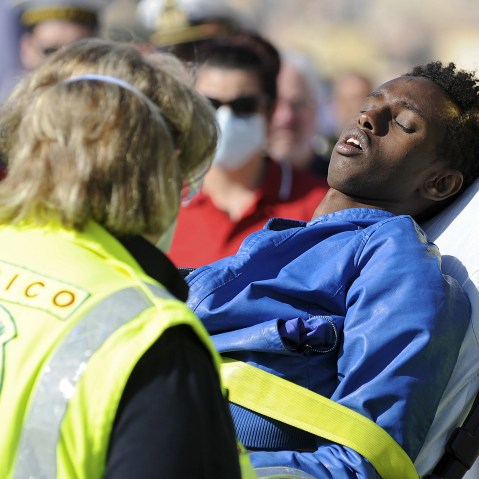 A migrant is helped as he disembarks from a Coast Guard boat in the Sicilian harbor of Palermo, April 18, 2015. (Photo by Guglielmo Mangiapane/Reuters)