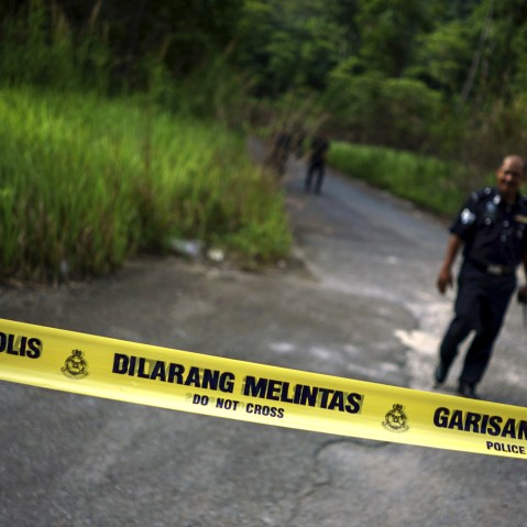 A Malaysian policeman leaves the site of the place where human remains were found, near an abandoned human trafficking camp, in the jungle close to the Thailand border at Bukit Wang Burma in northern Malaysia, May 29, 2015. (Athit Perawongmetha/Reuters)