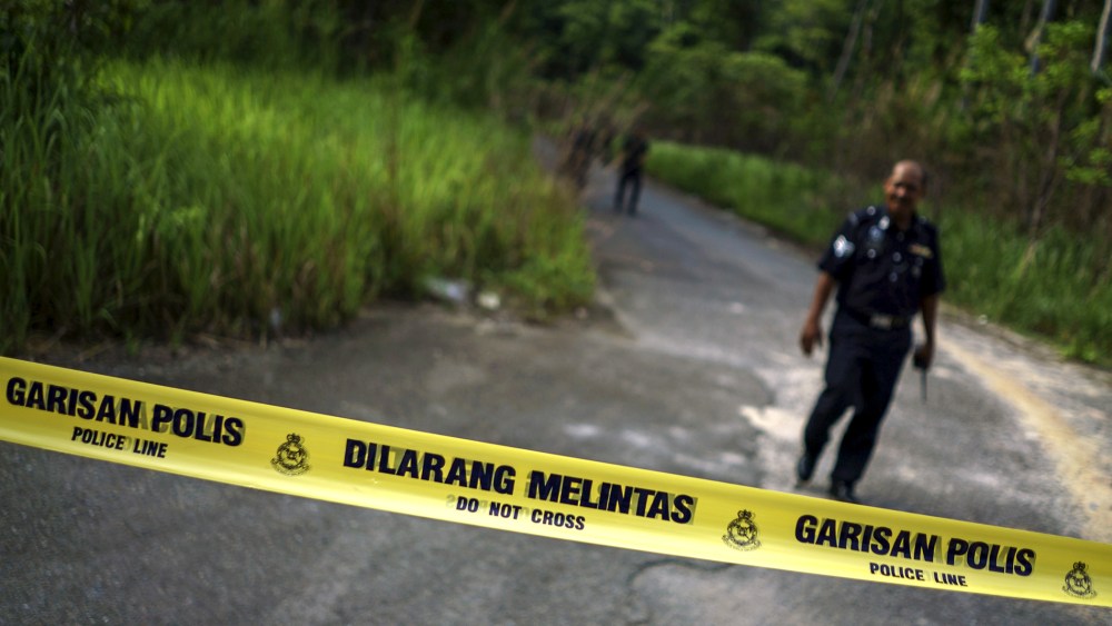 A Malaysian policeman leaves the site of the place where human remains were found, near an abandoned human trafficking camp, in the jungle close to the Thailand border at Bukit Wang Burma in northern Malaysia, May 29, 2015. (Athit Perawongmetha/Reuters)