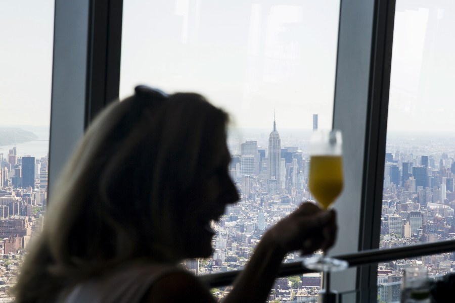 A woman laughs as she raises her drink at a restaurant in the newly opened One World Observatory in N.Y. on May 29, 2015. (Photo by Lucas Jackson/Reuters)
