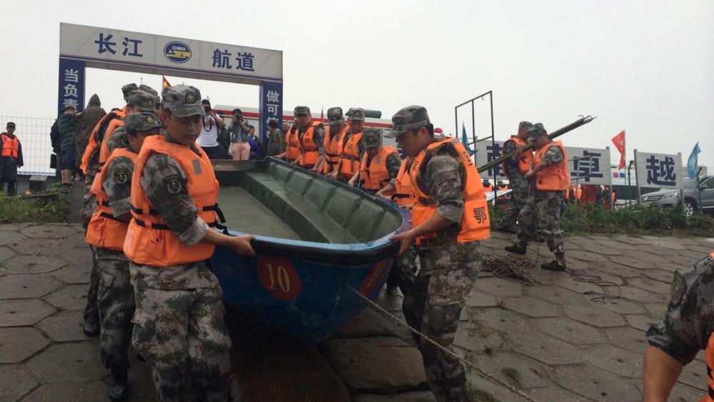Rescue workers carry a boat as they conduct a search, after a ship sank in the Jianli section of the Yangtze River, Hubei province, China, June 2, 2015. (Photo by Chen Zhuo/Yangzi River Daily/Reuters)
