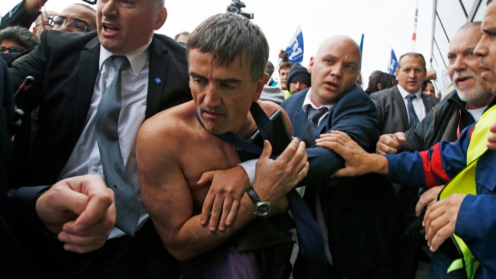 A shirtless Xavier Broseta (2ndL), Executive Vice President for Human Resources and Labour Relations at Air France, is evacuated by security after employees stormed into a meeting at the Air France headquarters in Roissy. (Photo by Jacky Naegelen/Reuters)