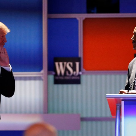 Republican U.S. presidential candidate and businessman Donald Trump whispers across to Dr. Ben Carson during a debate held in Milwaukee, Wis., Nov. 10, 2015. (Photo by Jim Young/Reuters)