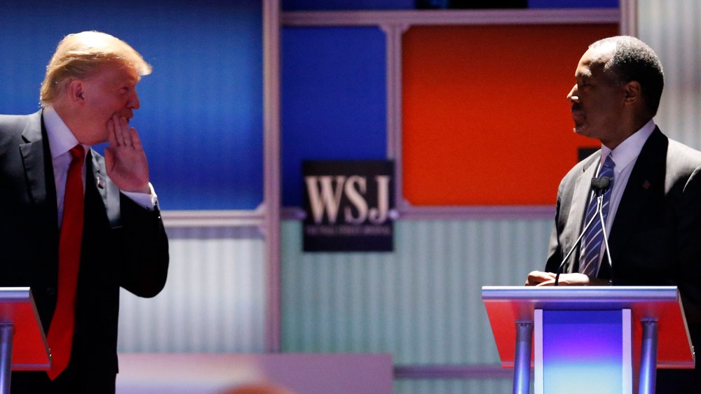 Republican U.S. presidential candidate and businessman Donald Trump whispers across to Dr. Ben Carson during a debate held in Milwaukee, Wis., Nov. 10, 2015. (Photo by Jim Young/Reuters)