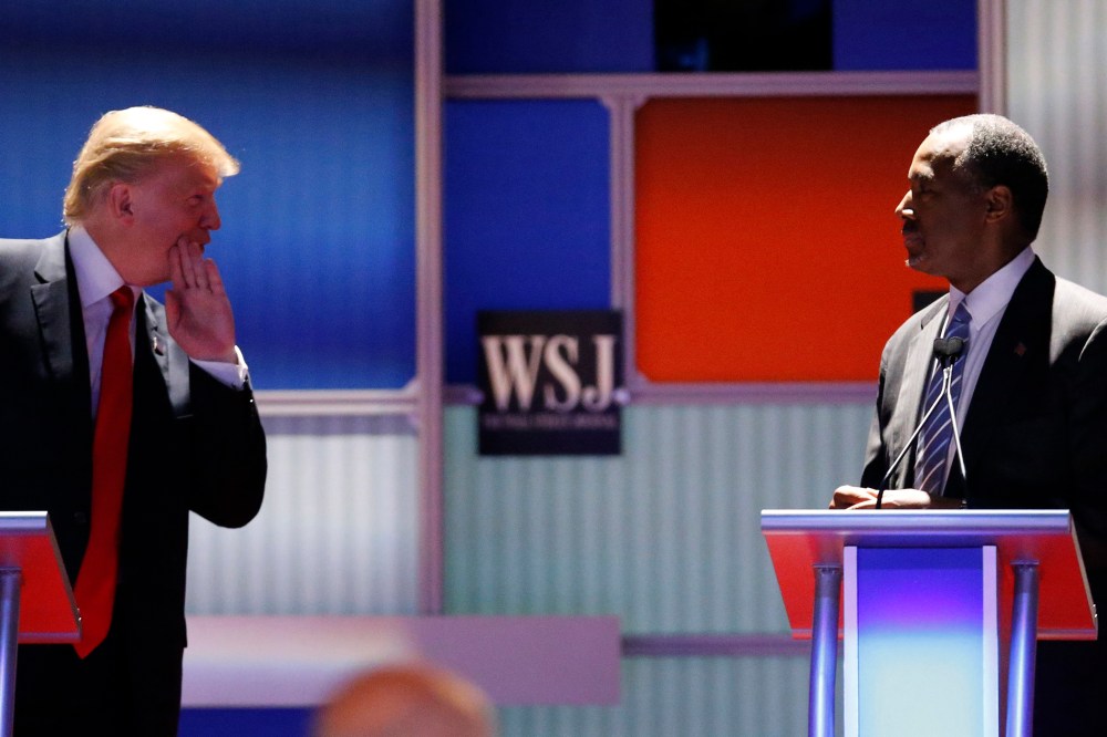 Republican U.S. presidential candidate and businessman Donald Trump whispers across to Dr. Ben Carson during a debate held in Milwaukee, Wis., Nov. 10, 2015. (Photo by Jim Young/Reuters)