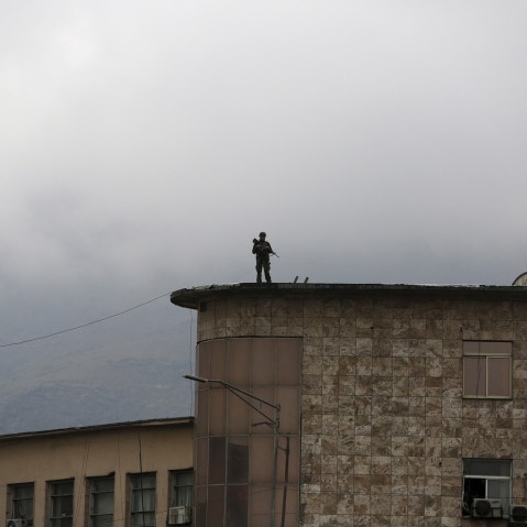 An Afghan security personnel keeps watch atop a building near the presidential palace during a protest against the killing of seven people from the Hazara community in Kabul, Afghanistan, Nov. 11, 2015. (Photo by Ahmad Masood/Reuters)