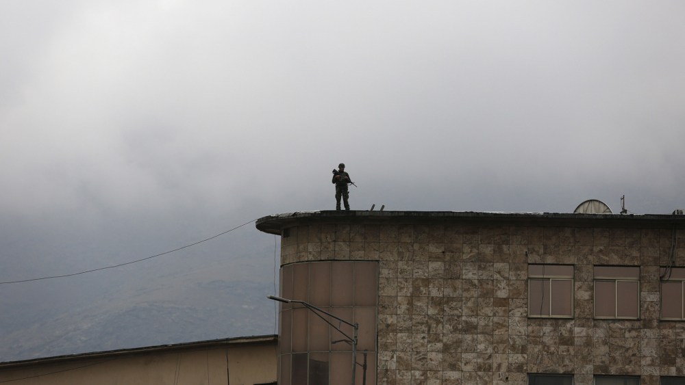 An Afghan security personnel keeps watch atop a building near the presidential palace during a protest against the killing of seven people from the Hazara community in Kabul, Afghanistan, Nov. 11, 2015. (Photo by Ahmad Masood/Reuters)