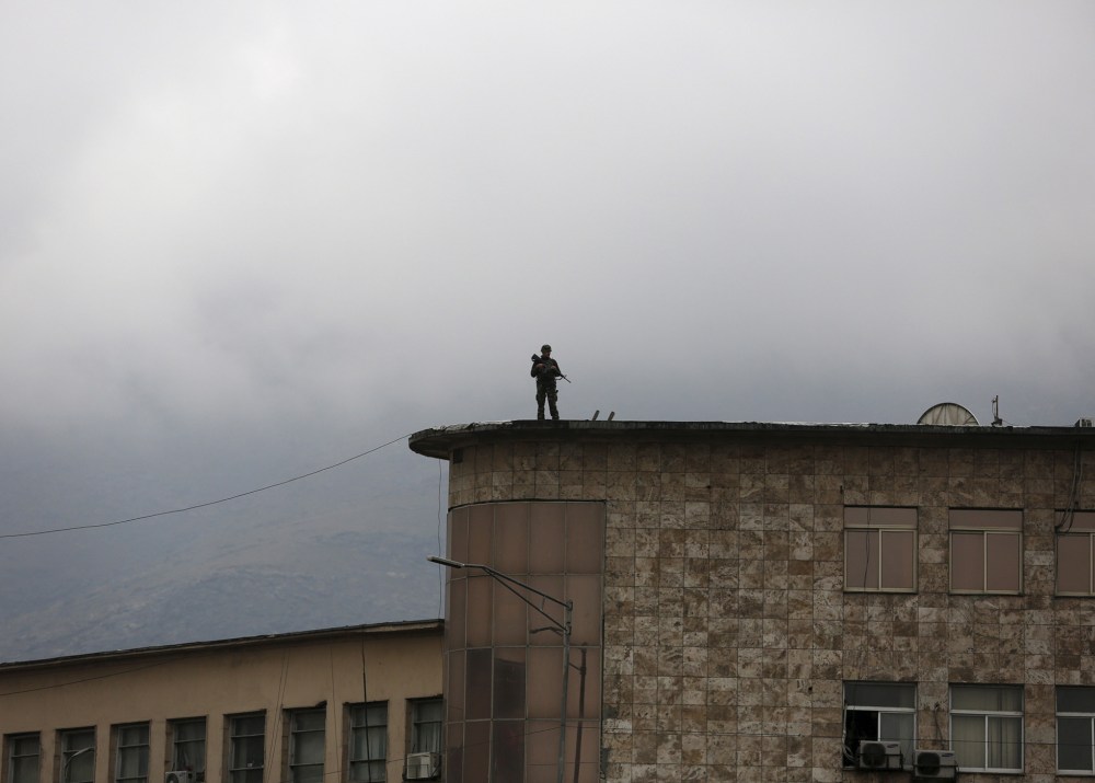 An Afghan security personnel keeps watch atop a building near the presidential palace during a protest against the killing of seven people from the Hazara community in Kabul, Afghanistan, Nov. 11, 2015. (Photo by Ahmad Masood/Reuters)