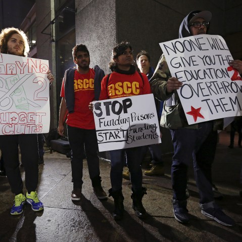 Students hold up signs as they attend a demonstration calling for lower tuition at Hunter College in Manhattan, New York, Nov. 12, 2015. (Photo by Carlo Allegri/Reuters)