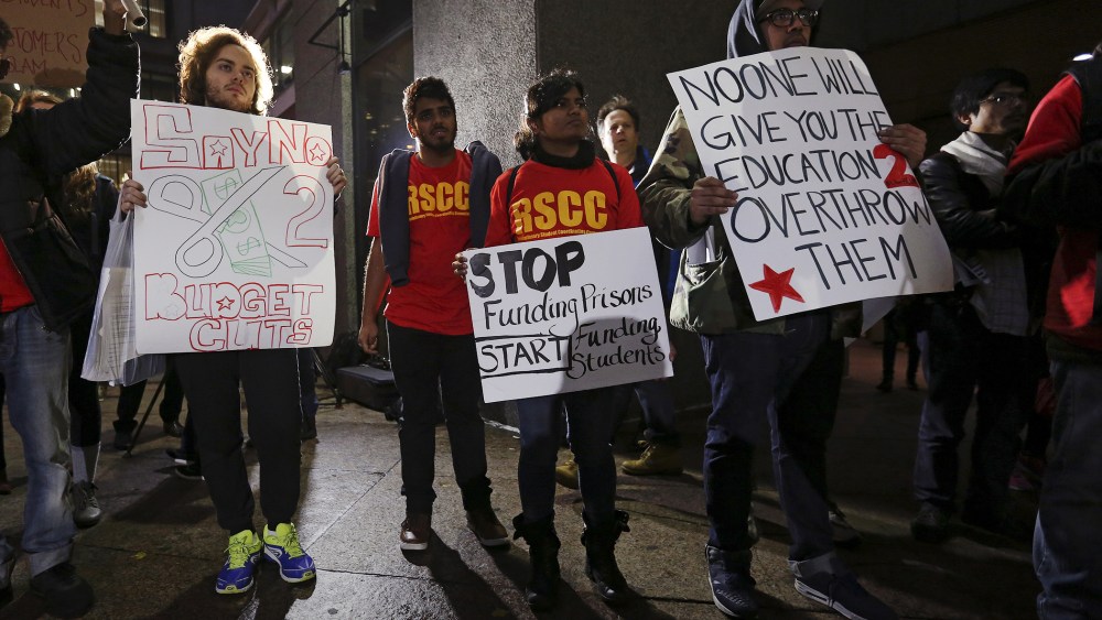 Students hold up signs as they attend a demonstration calling for lower tuition at Hunter College in Manhattan, New York, Nov. 12, 2015. (Photo by Carlo Allegri/Reuters)