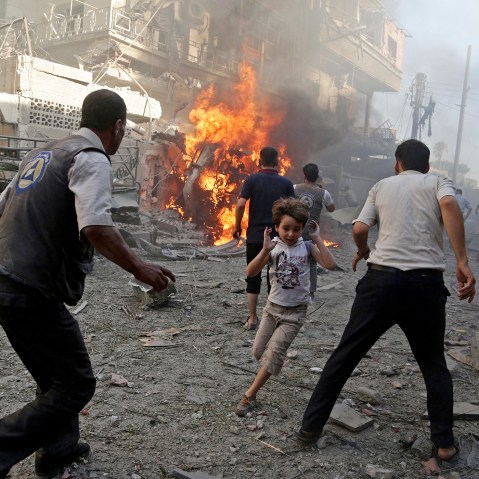 A boy runs as he rushes away from a site hit by what activists said were airstrikes by forces loyal to Syria's President Bashar al-Assad in the Douma neighborhood of Damascus, Syria, Aug. 24, 2015. (Photo by Bassam Khabieh/Reuters)