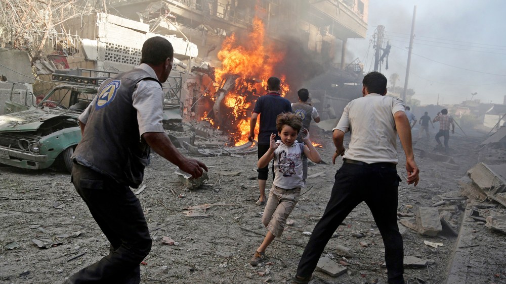 A boy runs as he rushes away from a site hit by what activists said were airstrikes by forces loyal to Syria's President Bashar al-Assad in the Douma neighborhood of Damascus, Syria, Aug. 24, 2015. (Photo by Bassam Khabieh/Reuters)