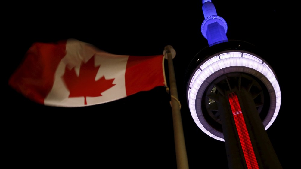The landmark CN Tower is lit blue, white and red in the colors of the French flag following Paris attacks, in Toronto, Nov. 13, 2015. (Photo by Chris Helgren/Reuters)
