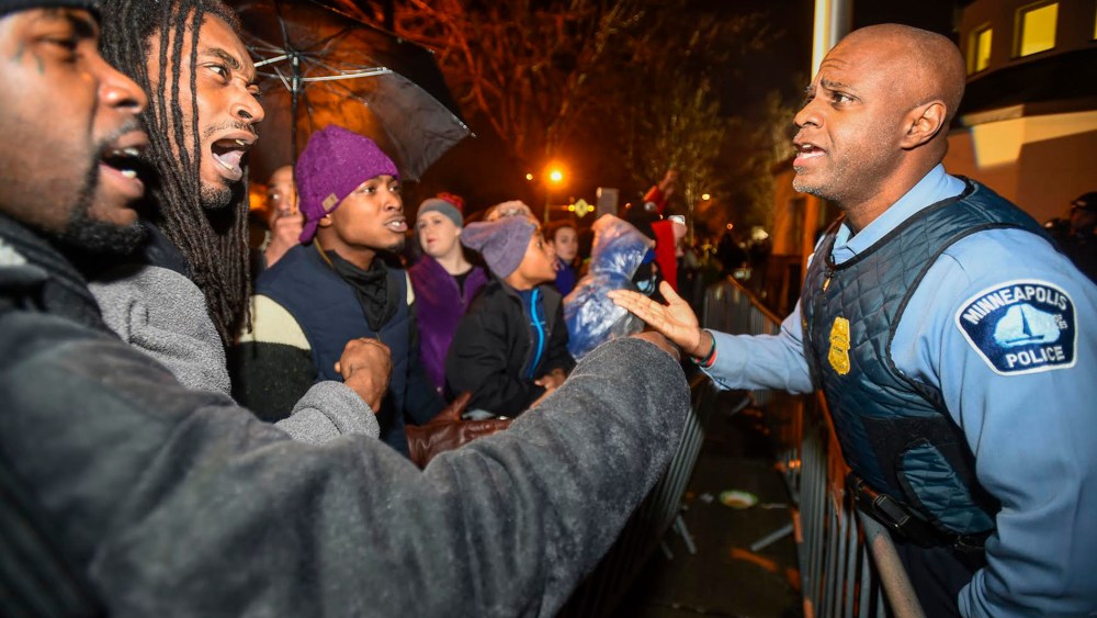 A police officer talks with demonstrators in front of a north Minneapolis police precinct during a protest in response of Sunday's shooting death of Jamar Clark by police officers in Minneapolis, Minn., Nov. 18, 2015. (Photo by Craig Lassig/Reuters)