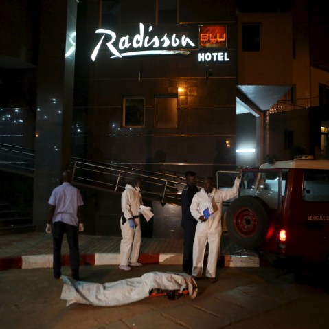 Malian officials prepare to lift a corpse into an emergency vehicle outside the Radisson hotel in Bamako, Mali, Nov. 20, 2015, where 27 people were killed on Friday after a hotel was seized by Islamist gunmen. (Photo by Joe Penney/Reuters)